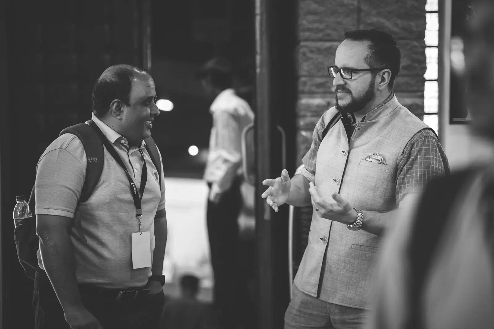 Michael mid-conversation with a conference attendee, hands open, explaining